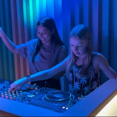 Here we are getting into the groove. I'm showing my student how to feel the rhythm and anticipate the next drop. It's all about building confidence behind the decks.