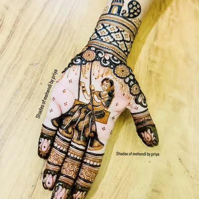 A special design for the Teej festival, featuring a woman on a swing (jhula). The hand is filled with intricate patterns, and the fingertips have a classic lotus design.