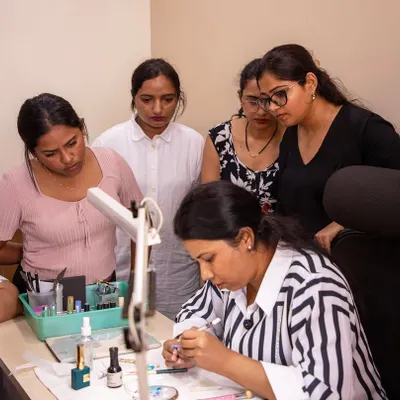 A moment of intense focus during a live demonstration. My students gather close to see every detail of the brushwork, which is crucial for learning intricate designs.