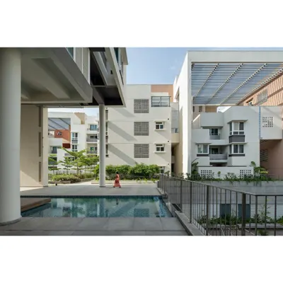 The common areas at Brigade Parkside East are designed for diverse activities. Here, the swimming pool is nestled between residential blocks, with multi-floor colonnades and ramps providing universal access and creating pavilions for community gatherings.