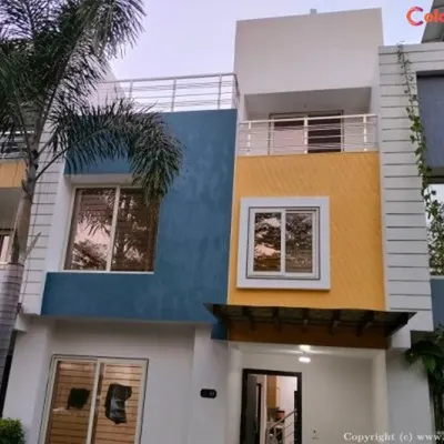 This modern villa's exterior was transformed with a durable, weather-resistant paint combination. We used a sophisticated palette of blue, yellow, and white to enhance the building's architectural features and provide long-lasting curb appeal.