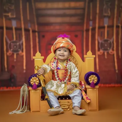 Your little warrior king, seated confidently on his throne. This Bal Shivba theme photoshoot captures the royal grace and power associated with Shivaji Maharaj.