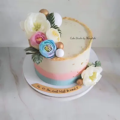 A lovely floral baby shower cake with soft hues of pink and blue. The message "He or She, Can't Wait to Meet You" makes it perfect for a gender reveal party.