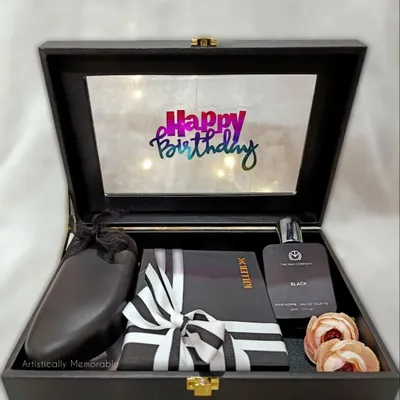 An open view of a classic men's birthday hamper. This one features a light-up lid, a sleek wallet, perfume, and other accessories, all nestled in a reusable suede box.
