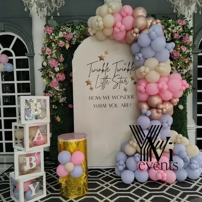 An elegant baby shower setup with a "Twinkle Twinkle Little Star" theme. It features a pastel balloon arch, "BABY" blocks, and a custom backdrop for a gender reveal party.
