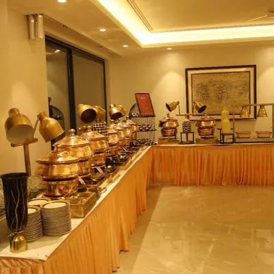 A full view of my buffet setup for a Grah Pravesh (housewarming) party. The arrangement features a long line of gleaming copper chafing dishes, neatly stacked plates, and elegant decor, creating a grand and welcoming feast.