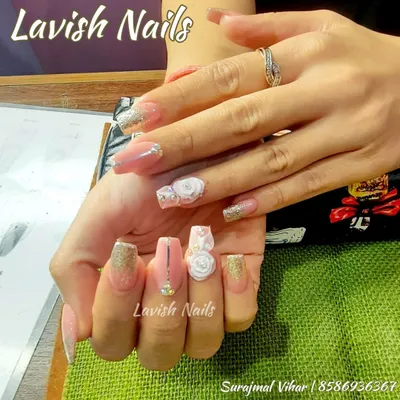 An exquisite bridal nail set featuring 3D white roses, gold glitter, and delicate rhinestone details on long pink acrylics.