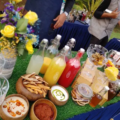 A vibrant spread of fresh ingredients for my Garden Fresh cocktail bar. This setup includes bowls of dips, breadsticks, and bottles of colorful, freshly squeezed juices and syrups ready for mixing.