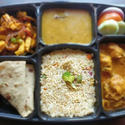 This is what a typical full meal looks like. It includes veg fried rice, chicken curry, paneer sabzi, dal, roti, and a fresh salad. A complete and satisfying meal delivered to you.