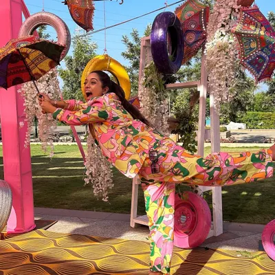 How do I stay so fit? By doing yoga in heels right in the middle of a show. A fun, quirky shot from a colorful Mehendi event, showing off my playful side and a very unique outfit.