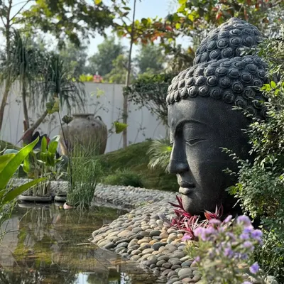 A perfect example of tranquility from a client's garden. The large 'Lama Buddha' statue creates a focal point for meditation and calm, beautifully integrated with the natural landscape and water feature.