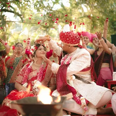 A moment of pure celebration as the couple is showered with rose petals by their loved ones during the ceremony.