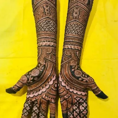 A full-coverage engagement mehendi with symmetrical patterns. The design features a mix of geometric grids, paisleys, and floral elements for a rich and detailed look.