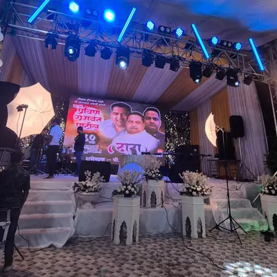 A stage setup for a large birthday celebration, featuring a prominent central LED screen. The professional lighting truss above is equipped with programmable lights to create dynamic effects that match the event's energy.