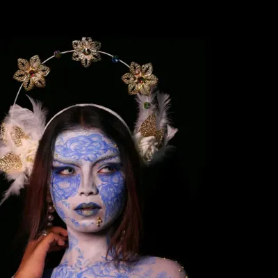 A portrait that transcends reality. This is a high-concept fantasy shoot, where we used intricate blue and white body paint and a custom floral headdress to create a living piece of art.