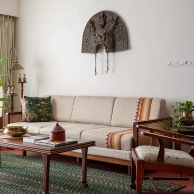 The living area of the Layam residence, featuring our Gubbi Sofa with a custom hand-block printed pattern reminiscent of the 'kara' border in Kerala textiles. The space is completed with the Kathakali-inspired Layam center table.