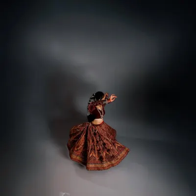 A portrait of movement and solitude. The swirl of the lehenga is captured in a dance of shadow and light, creating an image that is both dynamic and deeply introspective.