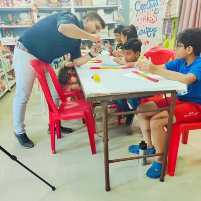 Our Robotics 101 session in full swing. Here, our instructor is explaining the basics of circuits to an engaged group of young innovators.