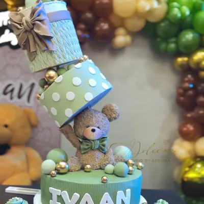 A close-up of our topsy-turvy teddy bear cake, made for Ivaan's first birthday. The design features stacked, angled gift boxes and a sweet, handcrafted teddy bear, all balanced perfectly.