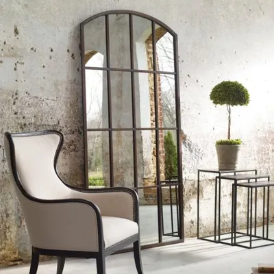 This grand, arched window-pane mirror serves as a stunning architectural feature in this living space. We crafted it to create an illusion of space and light, using a rustic metal frame for a classic, industrial-loft feel. We build large-scale statement mirrors to your exact dimensions.