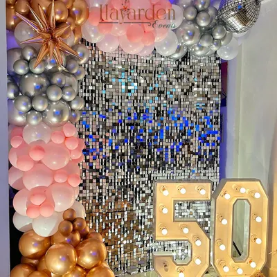 A fabulous 50th birthday celebration. The large light-up '50' is the star of the show, complemented by a silver sequin wall and a rose gold and pink balloon garland.
