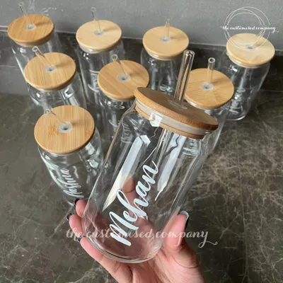 Cheers to staying hydrated! These personalized glass can-style sippers with bamboo lids and glass straws are a stylish and eco-friendly way to enjoy your favorite beverages.
