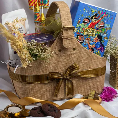 This jute basket hamper captures the essence of a traditional Diwali. It's filled with our signature chocolate chip cookies, a jar of dry fruits, chocolate pataka crackers, and a hand-painted diya, making it a complete and thoughtful gift for your loved ones.