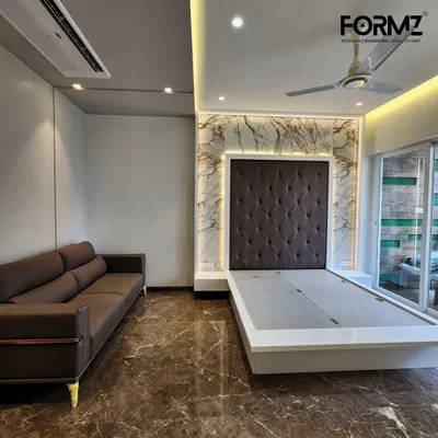 Here, a classic diamond-tufted headboard in dark fabric is framed by a stunning marble-effect feature wall with warm backlighting. The sleek, low-profile bed frame is designed with a lift-up mechanism for convenient under-bed storage.