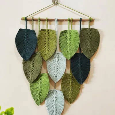 This large, cascading leaf wall hanging is one of my signature pieces. I used various shades of green and grey cotton cord to create a design that feels lush and natural, like foliage on a wall.