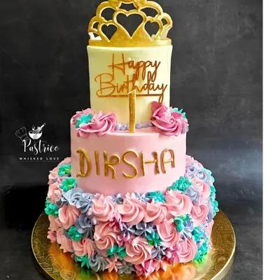 A beautiful two-tiered princess cake for a first birthday, with a cascade of colourful frosting rosettes and an edible gold crown.