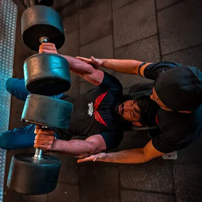 An overhead shot of a heavy dumbbell chest press, a fundamental exercise for building chest mass and strength. My spotter ensures I can push to failure safely.