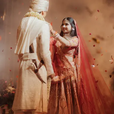 The Jaimala ceremony is a moment of beautiful anticipation. As Tanishqa places the garland, surrounded by a shower of petals, we capture the beginning of their union with a sense of cinematic grandeur.