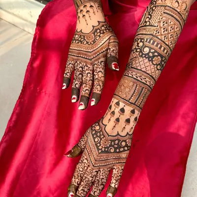 A stunning backhand design for an engagement, with a V-shaped pattern that elongates the hands and intricate details up the arm.