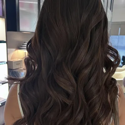 This rich mocha balayage blend adds subtle dimension to long, dark hair. I finished with a long layered haircut and soft waves to showcase the movement and healthy shine.