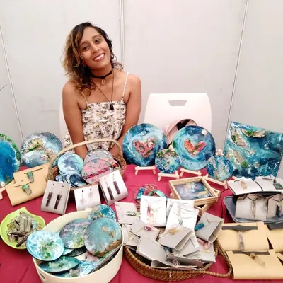 Me at my pop up stall at Maker Mela, surrounded by my handmade resin art. I love interacting with people and seeing their faces when they realize each piece is handcrafted, often from repurposed materials.