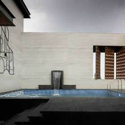 The rooftop swimming pool at The House of Dancing Screens is a luxurious centerpiece. It is flanked by a terrace garden and dynamic screens, and extends seamlessly into a spacious family lounge and entertainment area.