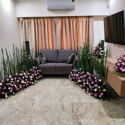 This is an example of a custom, modern floral installation for a living room. Instead of a traditional backdrop, we created artistic floor arrangements using tall sticks and bouquets of roses to decorate the space with a contemporary feel.