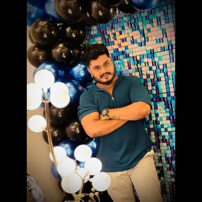 Here I am, standing in front of one of my favorite blue and black balloon creations. I love what I do, and it's a pleasure to bring so much joy to celebrations across Hubli.