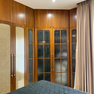 Custom wardrobes so sleek, even your clutter feels expensive. Cane meets glass and rich wood in this cozy corner glow-up.