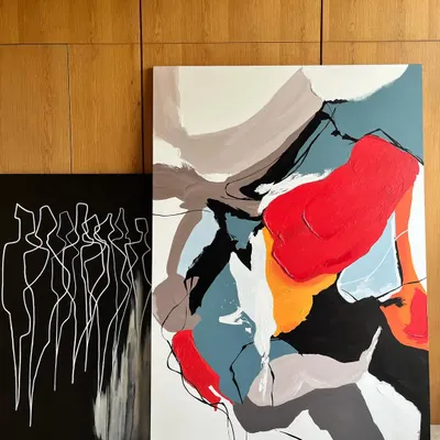 A pair of commissioned abstract canvases. One is a 'Colour Cluster' with bold, expressive shapes, while the other is a minimalist monochrome piece titled 'Bad shapes drawn carefully', exploring form through simple lines.