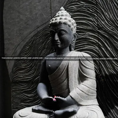 A close-up of a meditative Buddha statue, carved from stone with incredible detail. The textured, wave-like background adds to the sense of calm and focus.