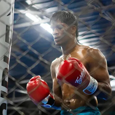 The calm before the storm. A fighter stands inside the cage, focused and ready. This image captures the mental preparation and concentration that is just as important as physical training.