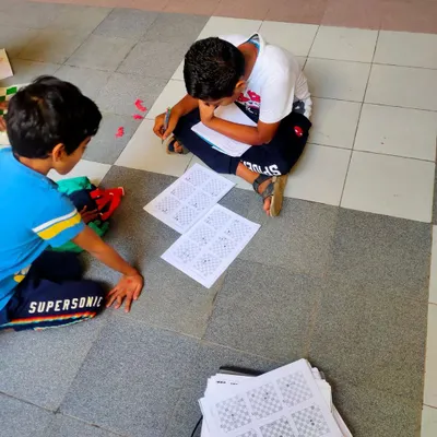 Putting knowledge to the test. Here, two students are working diligently on their chess exam worksheets. These assessments are designed to be challenging yet encouraging, allowing us to measure their understanding of concepts and identify areas for growth.