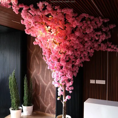 This magnificent artificial Cherry Blossom tree is a showstopper. Its vibrant pink blossoms and dramatic shape make it the perfect centerpiece for a hotel lobby, restaurant, or high-ceilinged home.