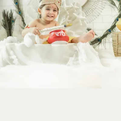 A close-up of a smiling baby dressed as little Krishna for a Janmashtami photoshoot. The details of the costume, the pot of butter, and the joyful expression make this a perfect festive portrait.