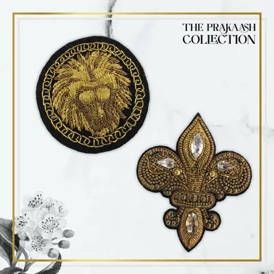 Two stunning hand-embroidered patches: a circular lion crest in gold thread and a fleur-de-lis motif embellished with stones and zari. These patches add a touch of heraldic elegance to any garment.