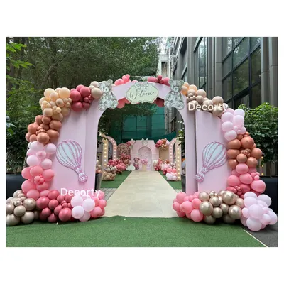 A grand entrance for a pink teddy bear themed party. The large arch is decorated with pink and rose gold balloons, welcoming guests to a beautiful outdoor celebration.