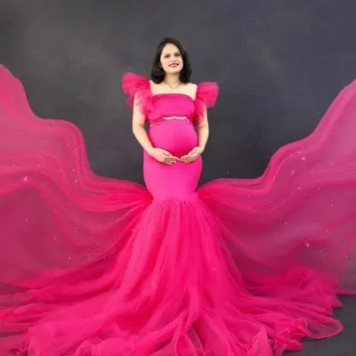Make a bold statement with this hot pink mermaid gown featuring a dramatic, sparkling train. This studio shot shows how the dress creates an incredible silhouette, perfect for a high-impact glamour portrait.