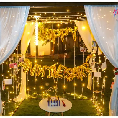 Our classic anniversary cabana is a world of its own. We use a sturdy frame draped with elegant white curtains and fill the space with fairy lights and "Happy Anniversary" balloons for a truly immersive romantic experience.
