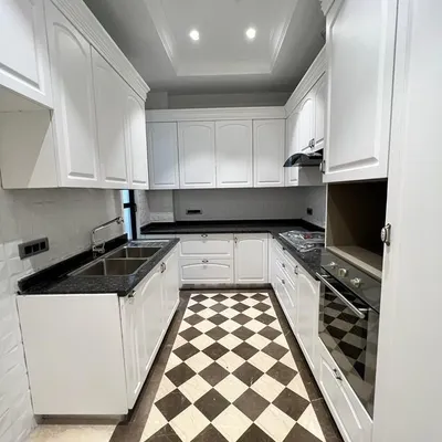 A kitchen that is both functional and beautiful. This space at C-257 features classic white cabinetry, a black granite countertop, and a timeless checkerboard floor, all with a premium PU finish.